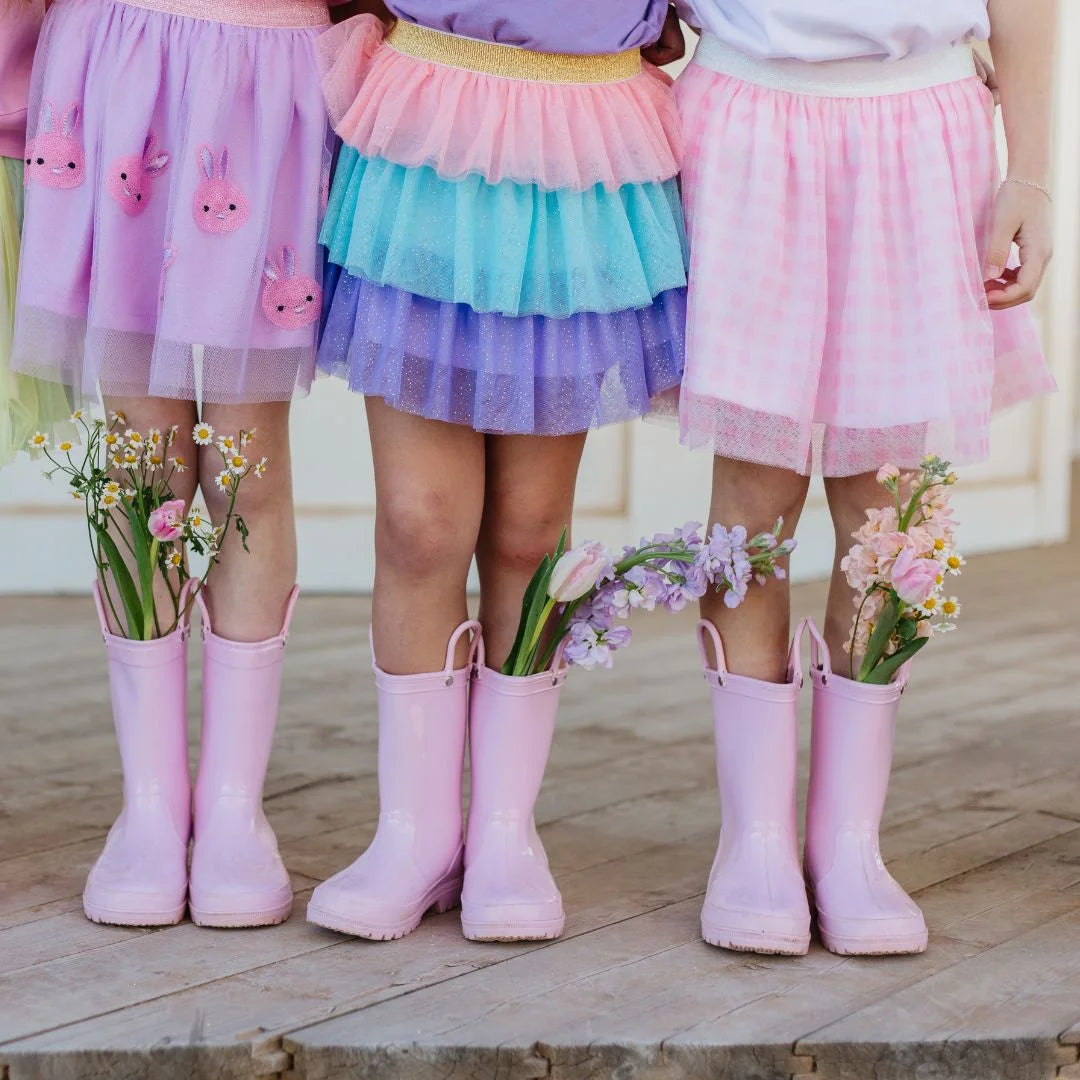 3 girls wearing different tutus with pink rainboots