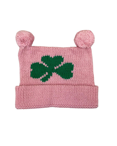 pink knit hat with two poms and green shamrock in center