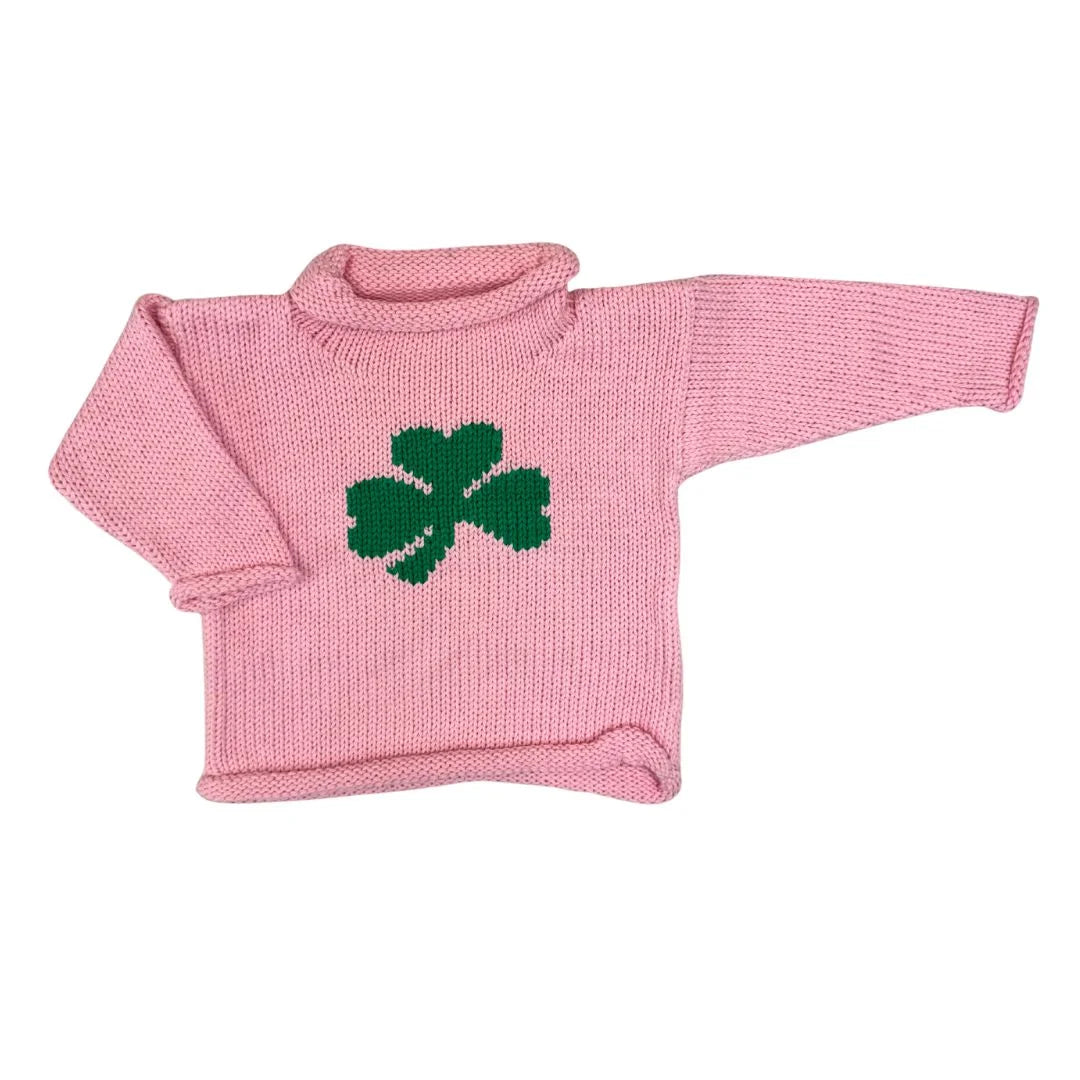 Pink knitted sweater with a green four-leaf clover design on a white background