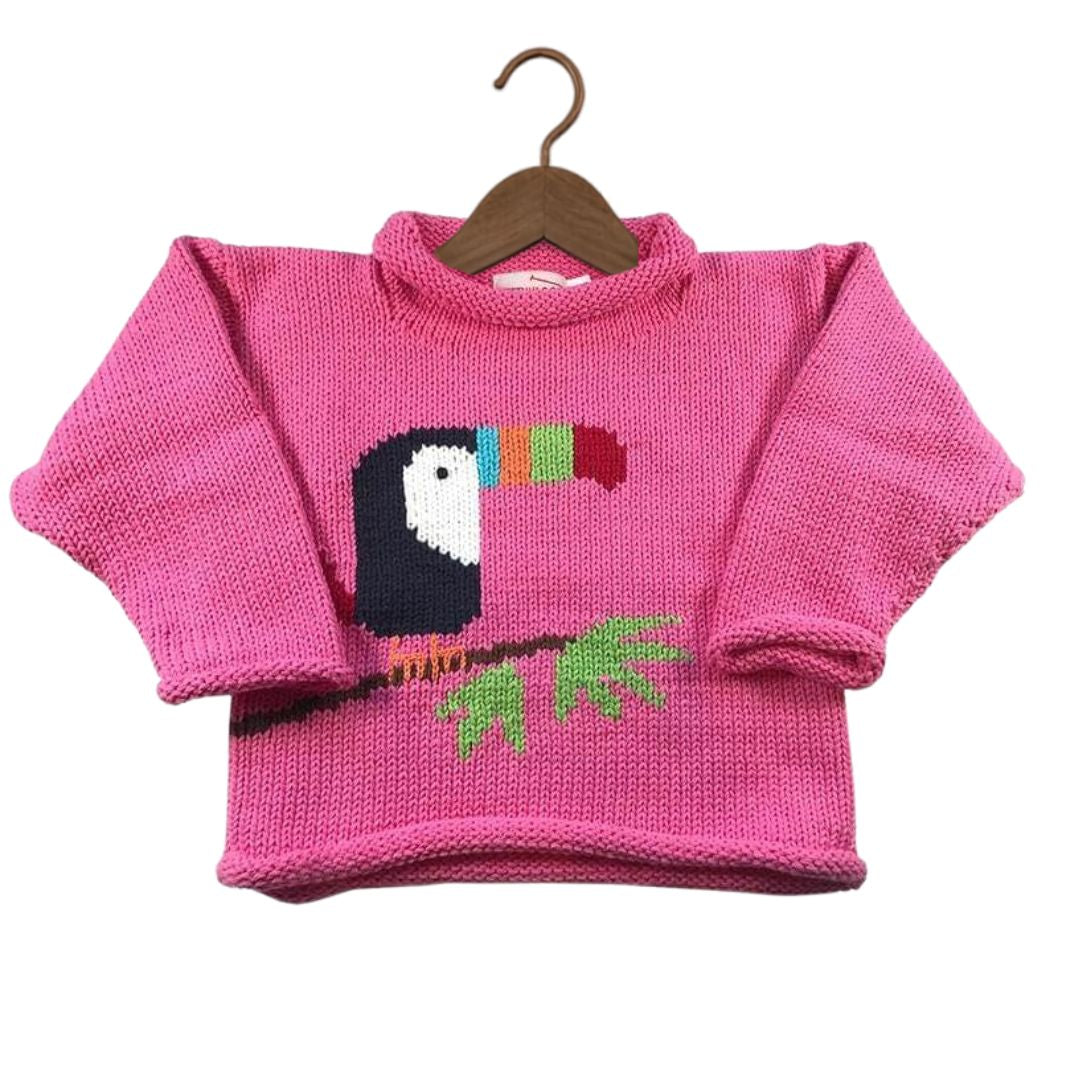 A bright pink knit sweater with a knitted toucan design on the chest, hanging on a wooden hanger against a plain white background.