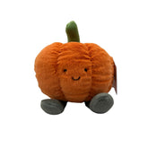 Plush pumpkin toy with a smiling face on a white background