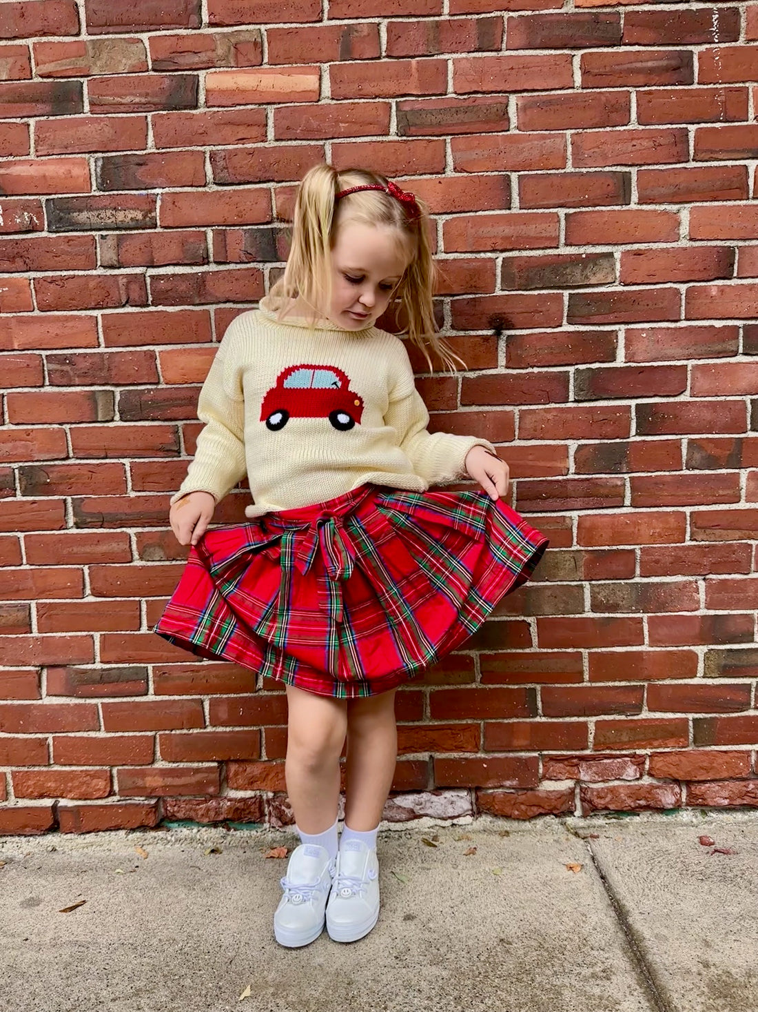 red car sweater paired with tartan skirt