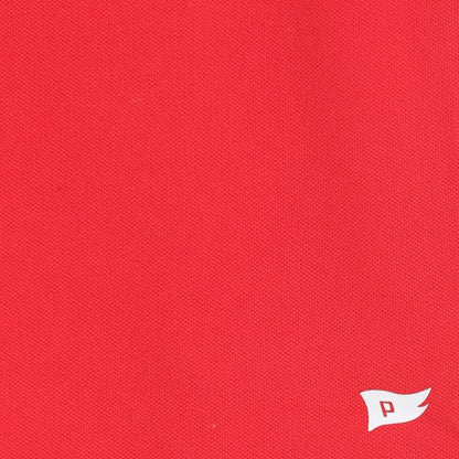 Close-up of red fabric with a small white logo on the bottom right corner.