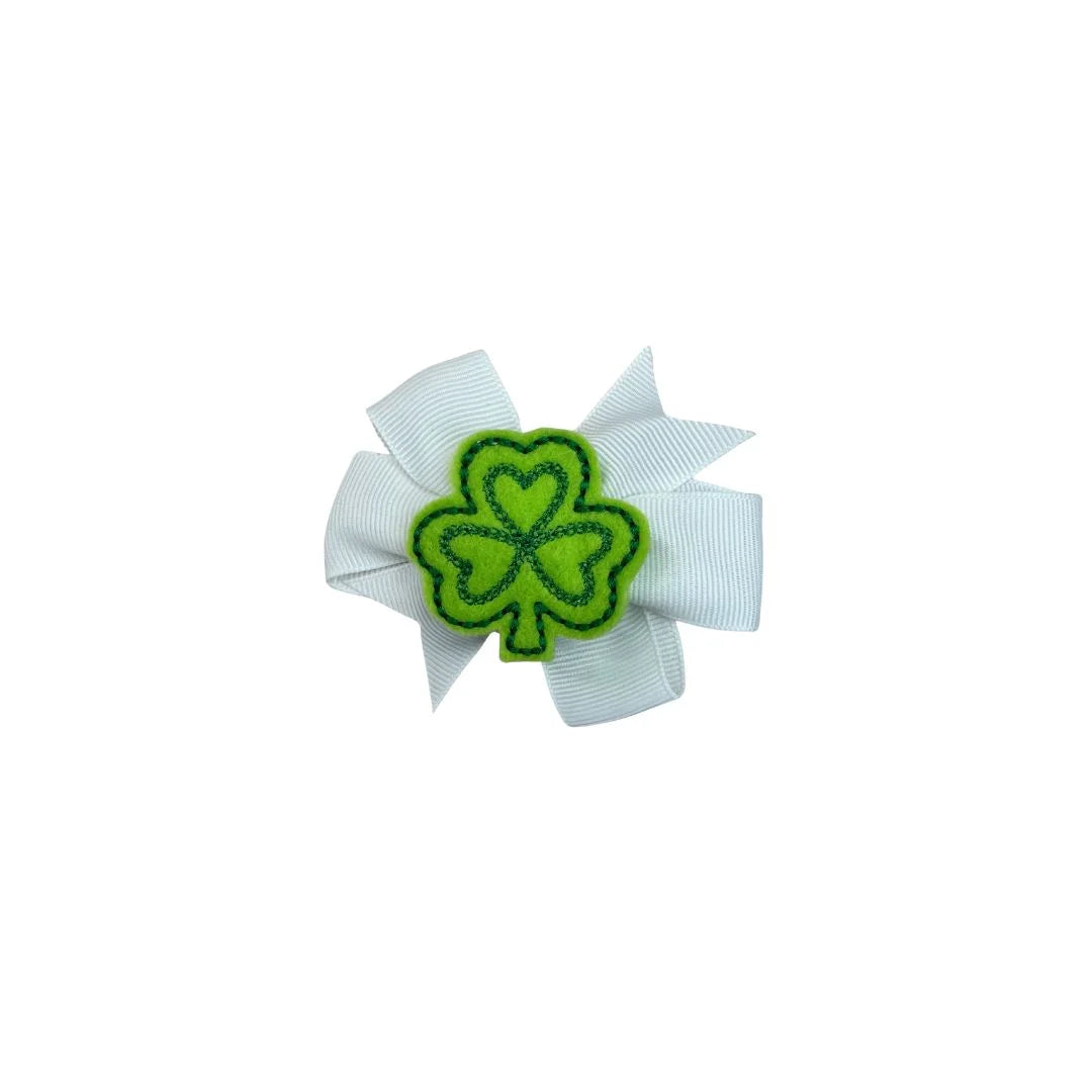 White hair bow with a green shamrock design on a white background