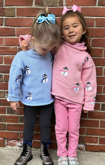 two girls wearing blue and pink snowmen sweaters