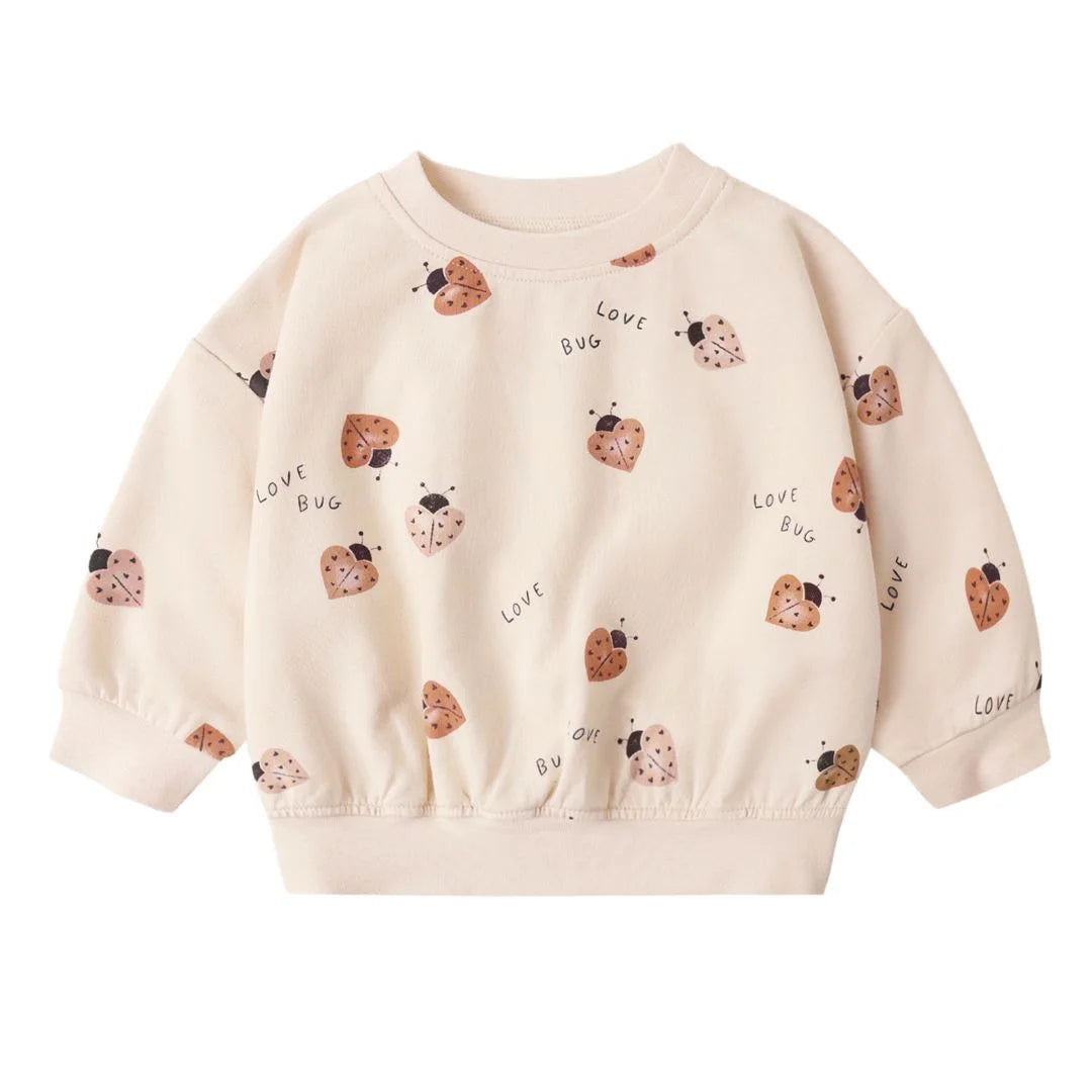 Beige sweatshirt with ladybug patterns on a white background