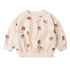 Beige sweatshirt with ladybug patterns on a white background