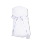 A white plush baby wrap or blanket with a matching white ribbon tied around it, featuring the brand name &