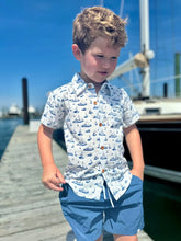 boy wearing sailboats shirt on dock