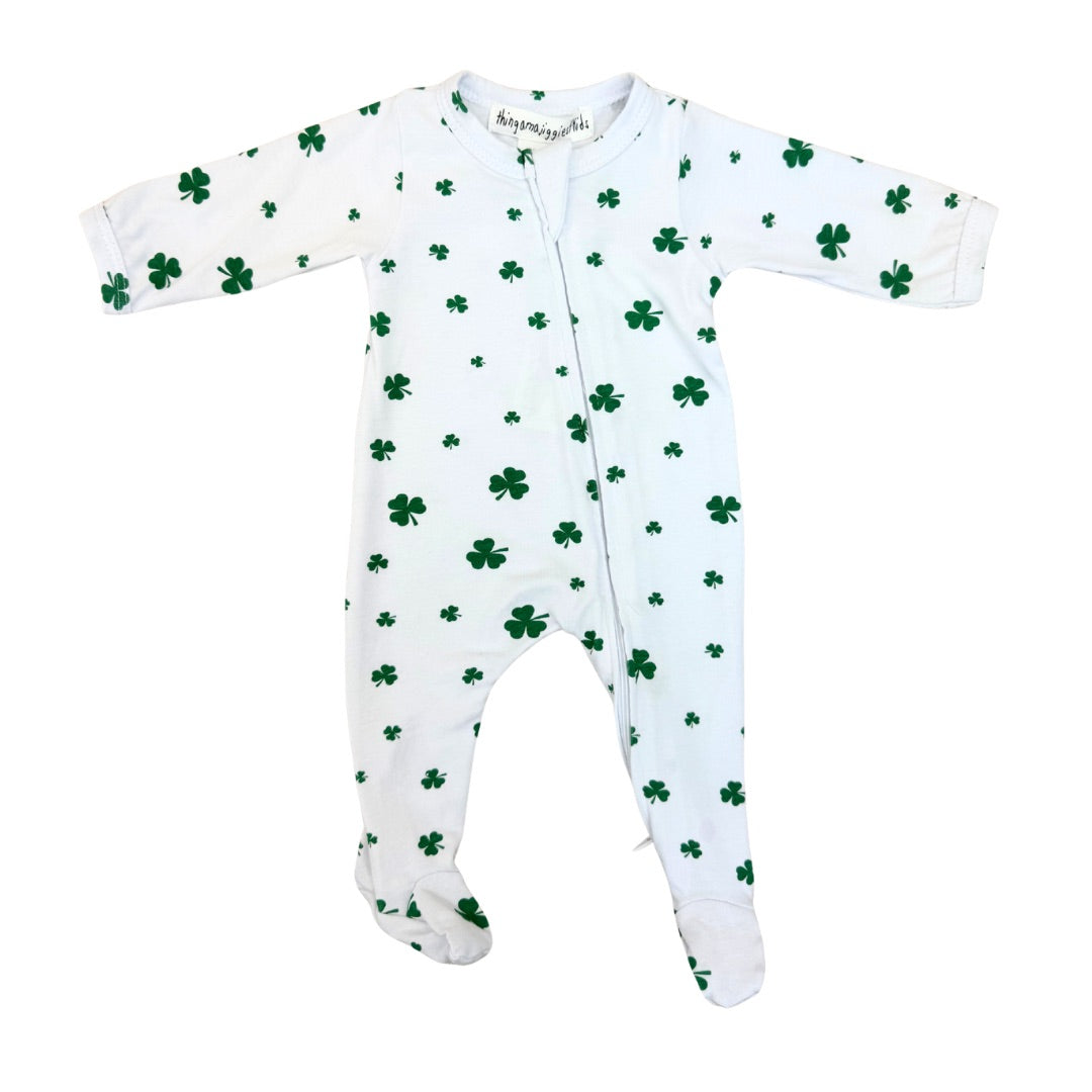 White baby onesie with green shamrock pattern on a white background