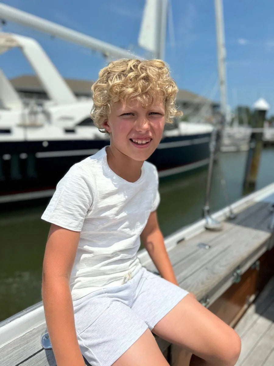 kid wearing shirt on a dock