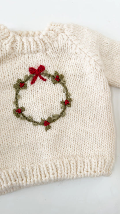 cream sweater with wreath on it