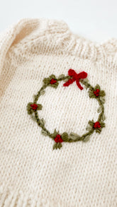 cream sweater with wreath on it
