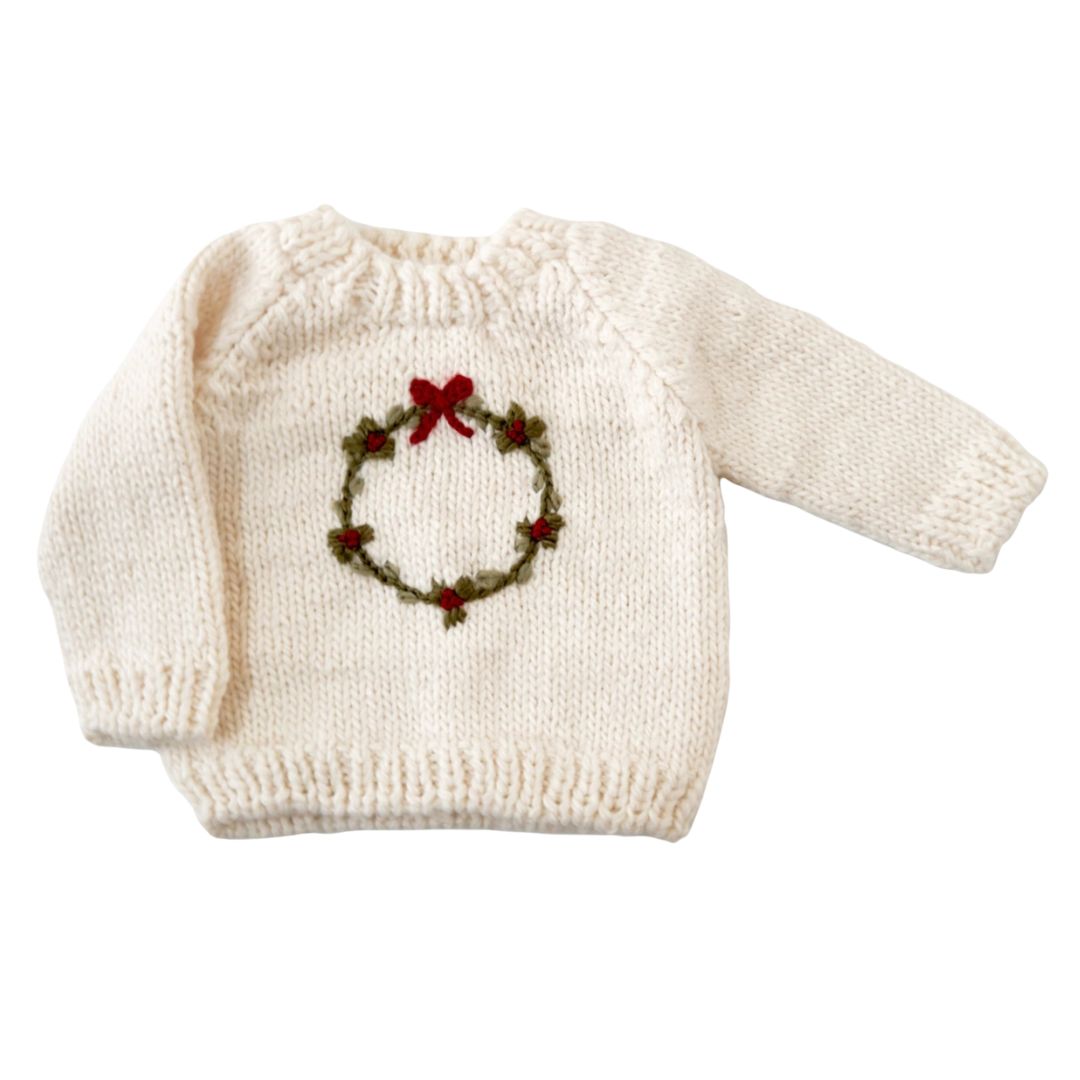 cream sweater with wreath on it