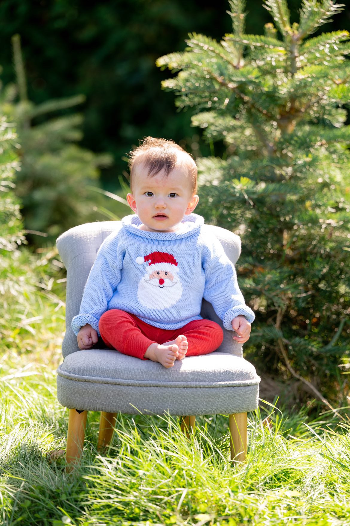 baby wearing santa sweater with red pants