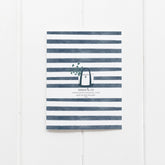 back of card with navy stripes and tote bag