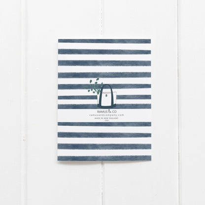 back of card with navy stripes and tote bag