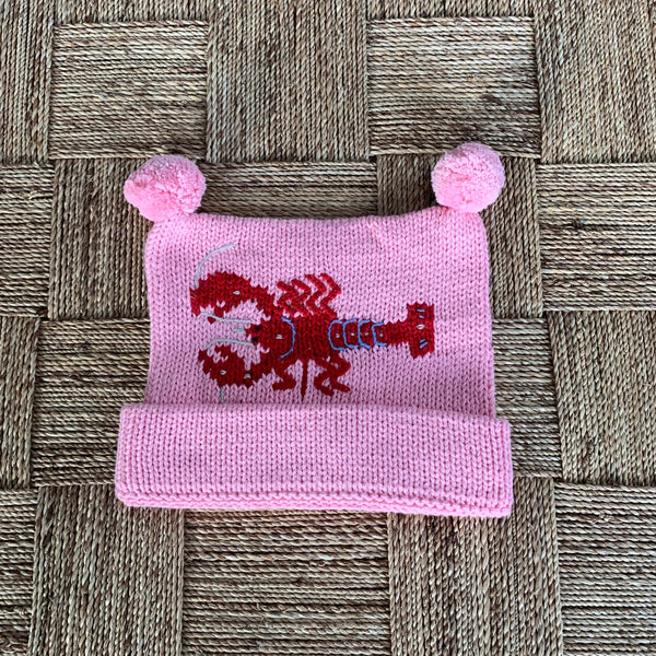 pink lobster hat on tan basket weave background