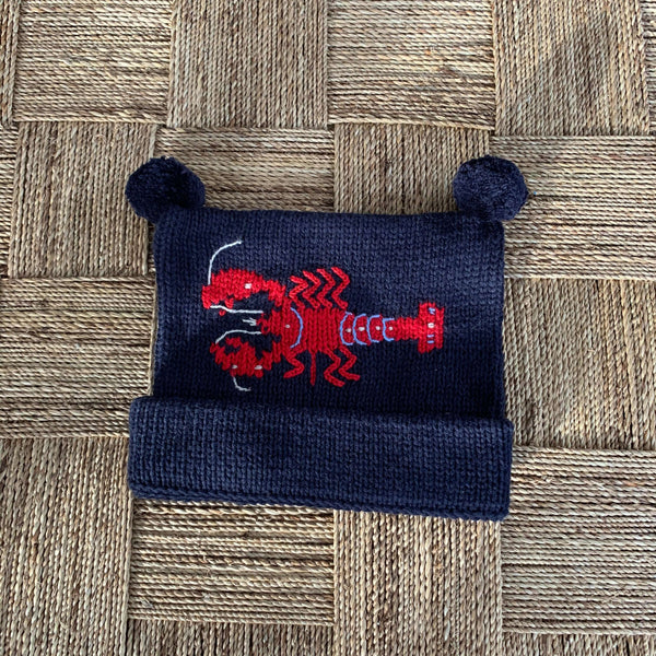 Navy Lobster Knit Hat on tan basket weave background