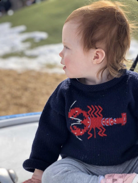 baby wearing Navy Lobster Roll Neck sweater looking to the side