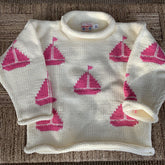 ivory roll neck sweater with pink sailboats knitted all over on basket weave background