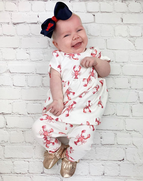 baby wearing lobster dress with lobster leggings and navy lobster bow