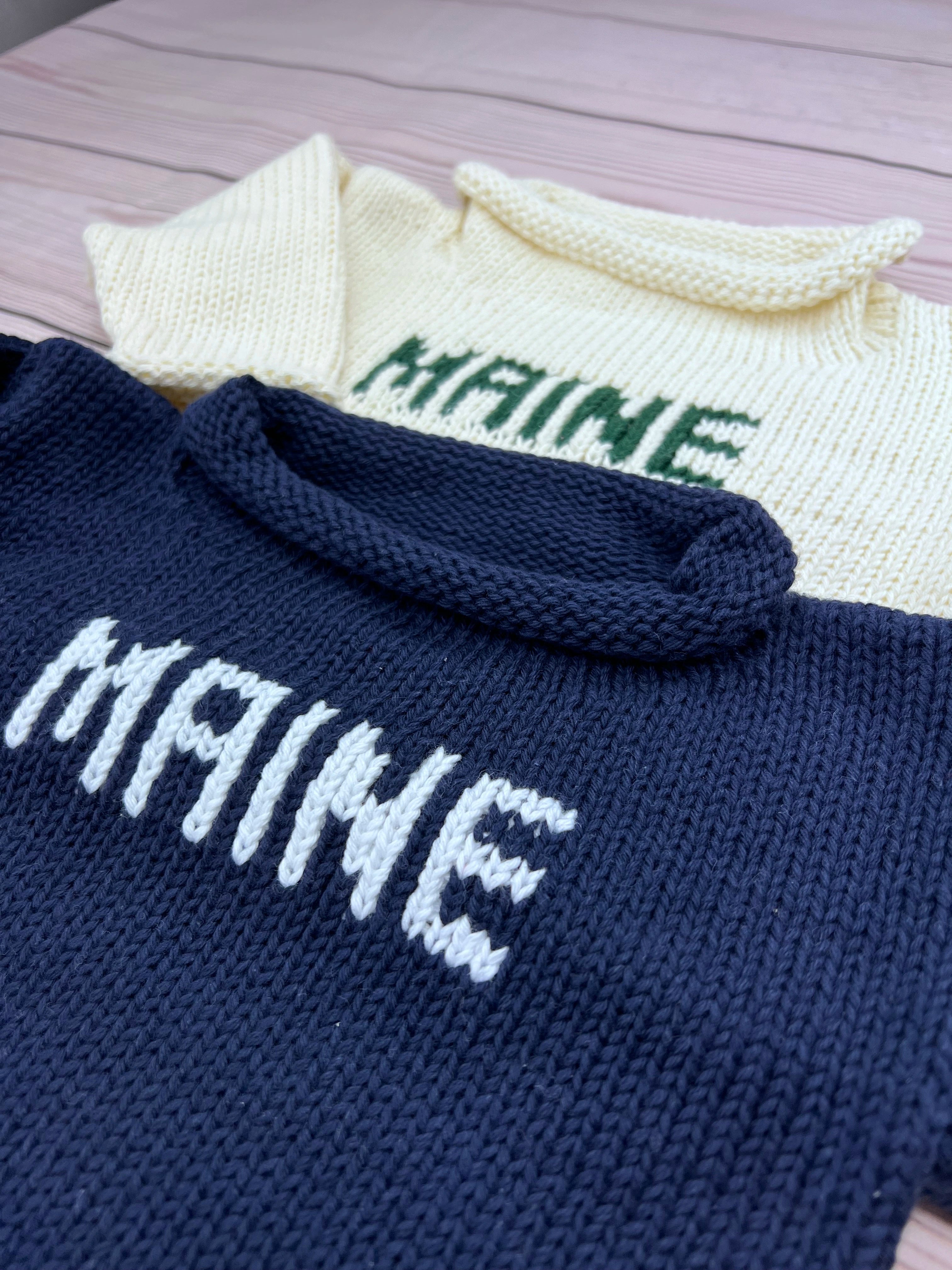 maine sweaters - one is ivory with green writing and one is navy with white writing