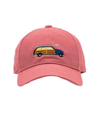 light red hat with navy and brown station wagon car with surf board on top