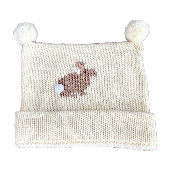 matching ivory knit hat with one tan bunny with white pom pom tail sewn on in the middle on the front of the hat. Hat has tw poms sewn on top and bottom of hat is rolled up once.
