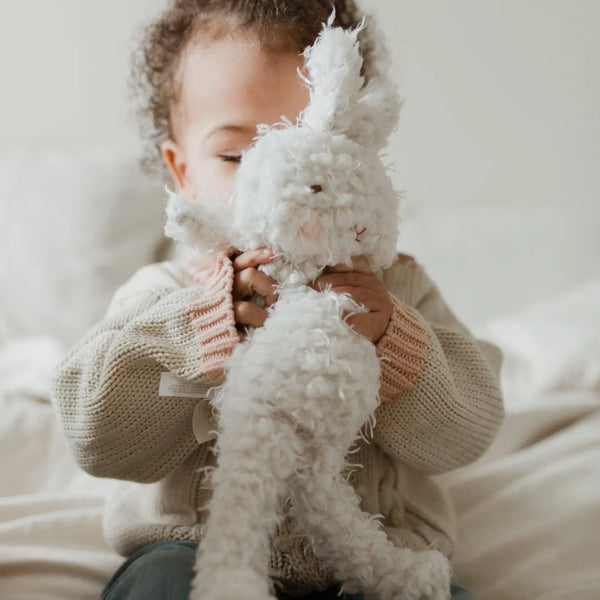 baby holding bunny plush