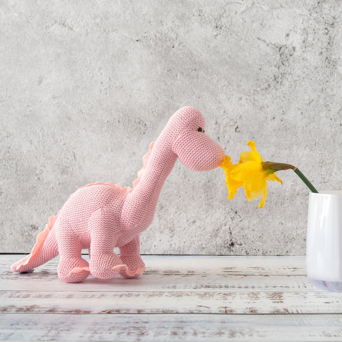dinosaur rattle next to a flower