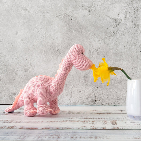 dinosaur rattle next to a flower