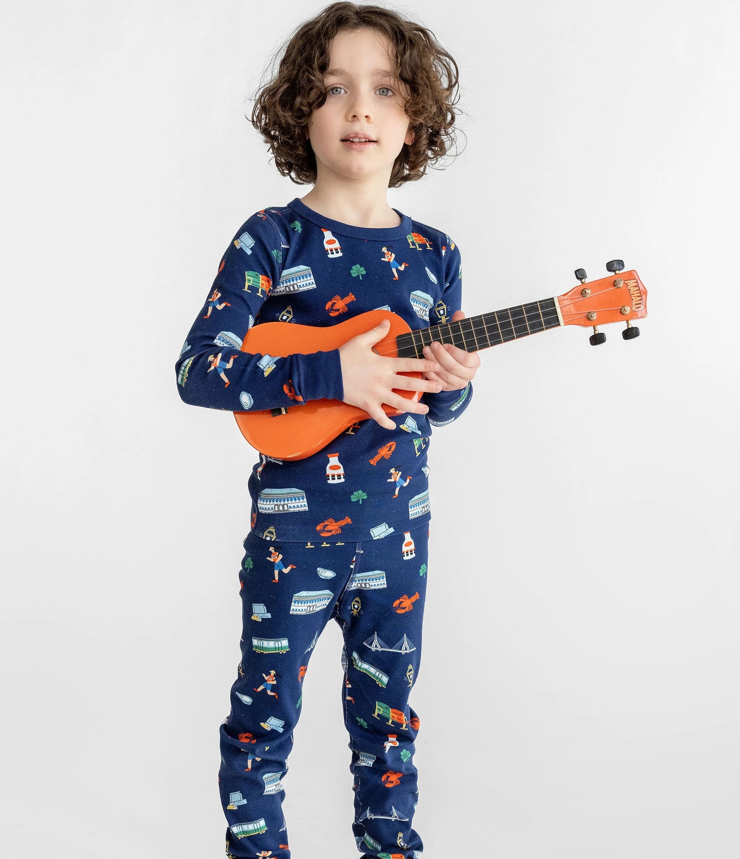 little boy wearing pajamas and holding ukulele