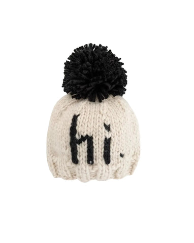 ivory hat with black "hi" knitted on and black pom at top
