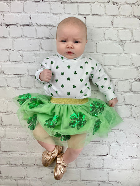 baby wearing turtleneck and green tutu