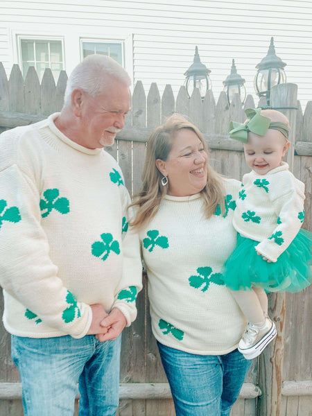 Man and woman wearing the Ivory Shamrock Sweater holding baby who is also wearing Ivory Shamrock Sweater with green tutu