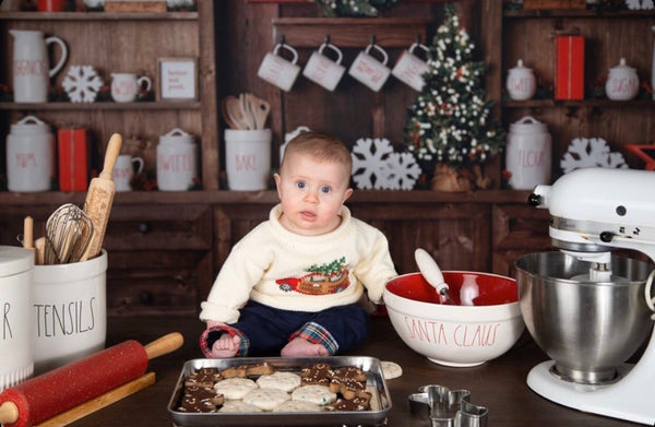 baby on table with christmas baking wearing the sweater