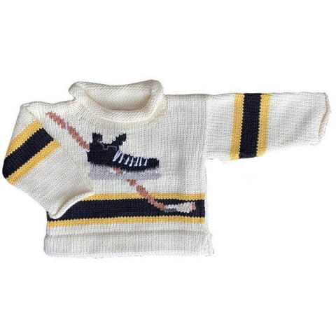 ivory roll neck sweater with black hockey skate with white laces and a tan hockey stick behind it. The bottom of the sweater has a black stripe which is outlined in yellow. This same stripe also appears on each sleeve once.