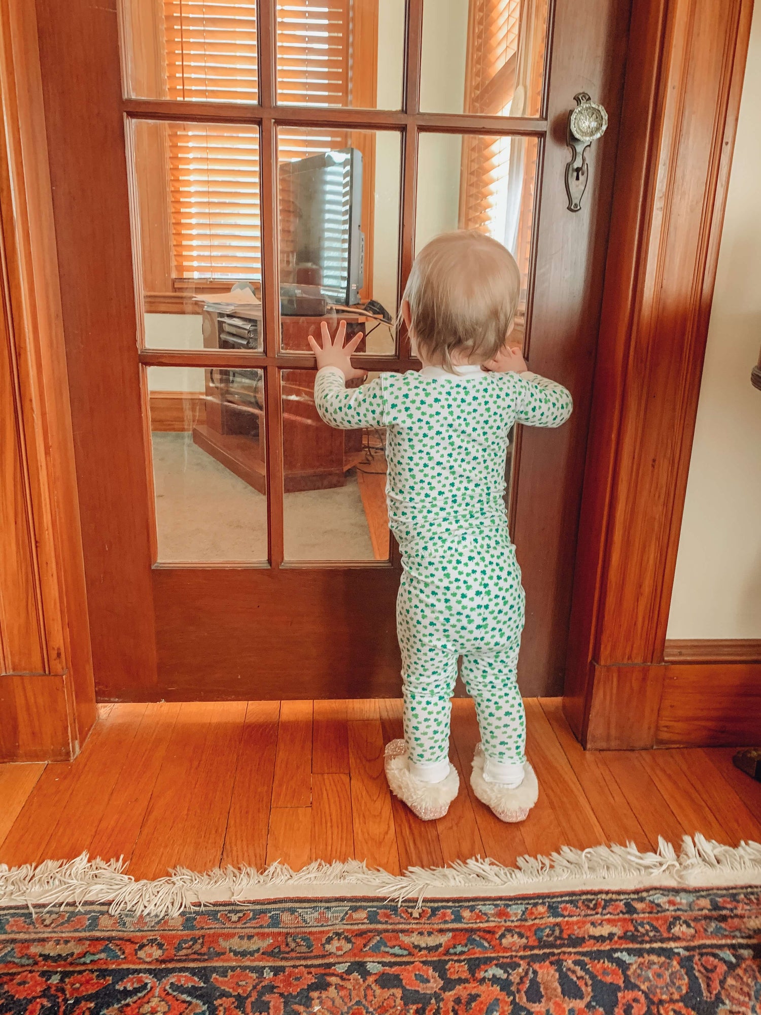 baby wearing shamrock pajamas, photo taken from behind