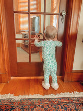 baby wearing shamrock pajamas, photo taken from behind
