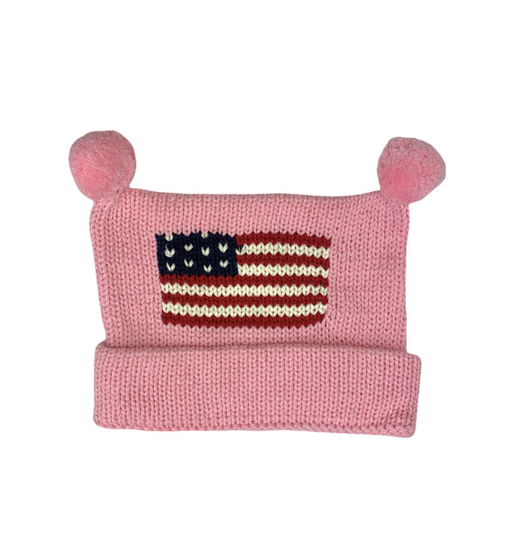 pink hat with bottom rolled up once and two pink poms at top and red white and blue american flag in center
