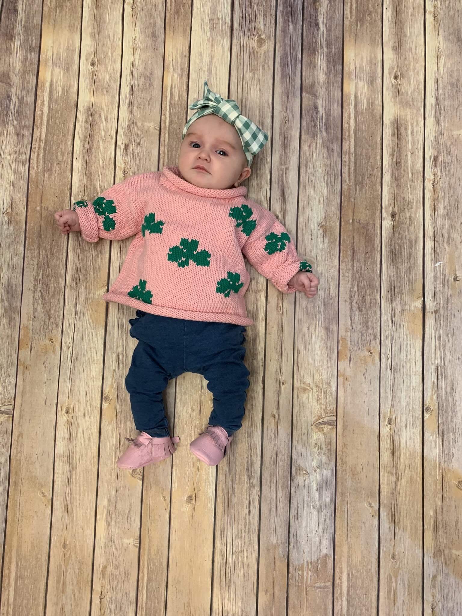 baby girl wearing pink shamrock sweater with jeans and pink moccasins