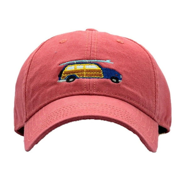 light red hat with navy and brown stationwagon with surfboard on top